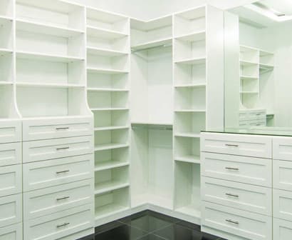 Custom walk-in closet with built-in shelving by Geet Glass & Closet